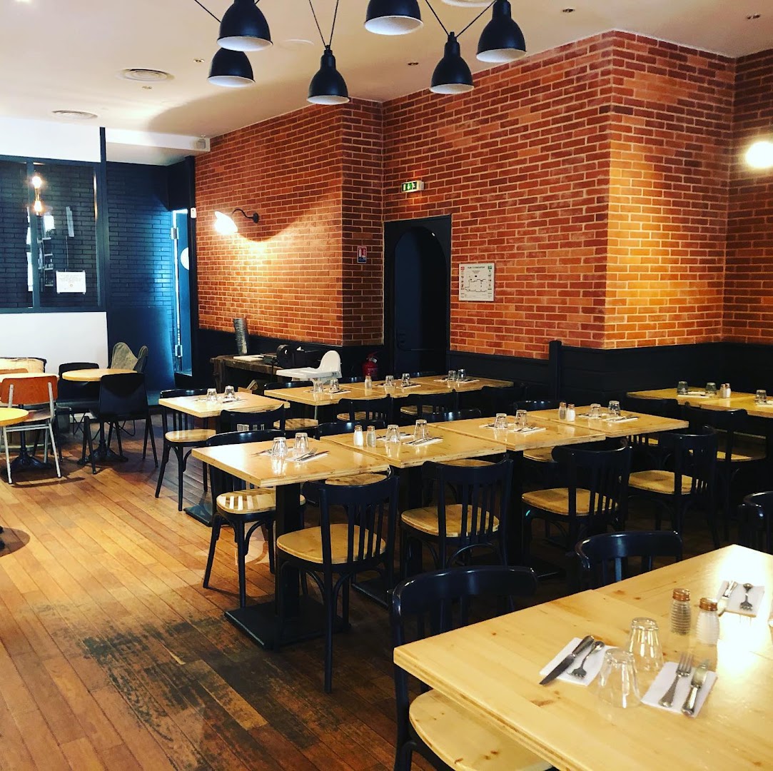 La salle du Bistro Montesquieu avec murs de brique et tables dressées